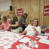 Teresa oversees the auction bidding and paying, with Leslie, Barbara, and Cindy helping. The live auction raised over $21,000!