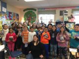 Laurie with 4th and 5th graders (holding copies of Villain Keeper.)