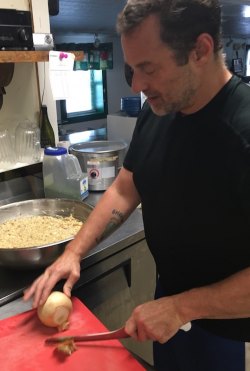 Jason Wells prepares fishcakes for the reopening of his restaurant.