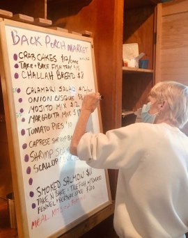 Tricia Palmisano adjusts the dry erase board to reflect item changes for the day.