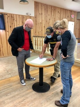 Hyde County Sheriff's deputy Blackburn Warner (center) discusses the floor plans with architect Ben Cahoon and middle school social studies teacher Gwen Austin.