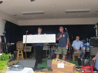 Auctioneer Philip Howard takes a break while Ernie makes the check presentation to Judy.