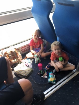 Sydney and Maddox of PA found a cozy spot to snack and play at their parents' feet. Their family chose to ride rather than wait in line for a car ferry.