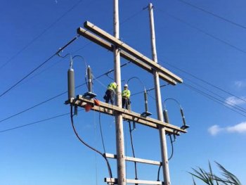 A crew from sister cooperative Brunswick EMC runs test on the transmission lines.