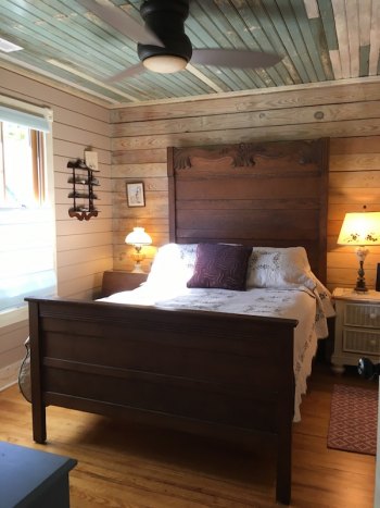 The center bedroom features an antique bed from the Phillips family and repurposed wood on ceiling and walls.