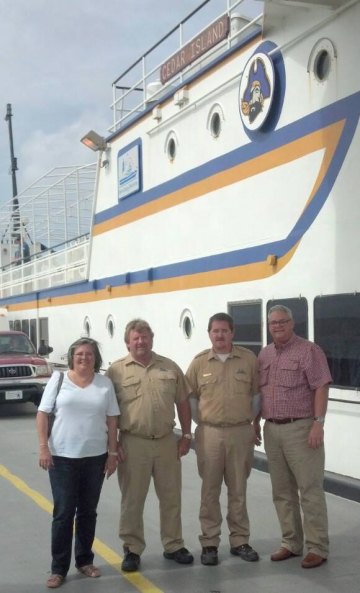 Renee and John Hoffman flanking the crew members who pulled them from Pamlico Sound.
