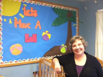 DeAnna poses in the baby room after the center's first day of the season.