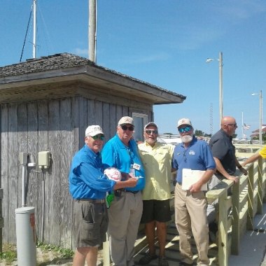 Inaugural passengers Archer Watkins (left) & Charlie Batchelor (second from right) pose with Ferry Division employees John McKenzie & LB Johnson. Capt. Watkins & Capt. Batchelor sailed to Ocracoke on their own boats then rode the Ocracoke Express for fun.