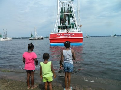 The crew of the Sea Angels waves to spectators at the Neuse River.