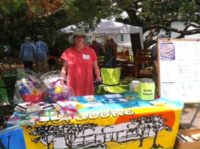 Community librarian Mary Bryant poses with the Friends of the Library booth at the Ocrafolk Festival in June. 