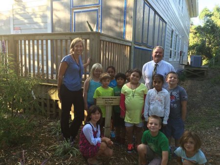 Alice Burruss poses with her former first graders and Ocracoke School principal Walt Padgett in the Dog Park. 