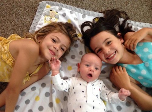 Bailey and Alyssa surround baby Pierce with sisterly love. 