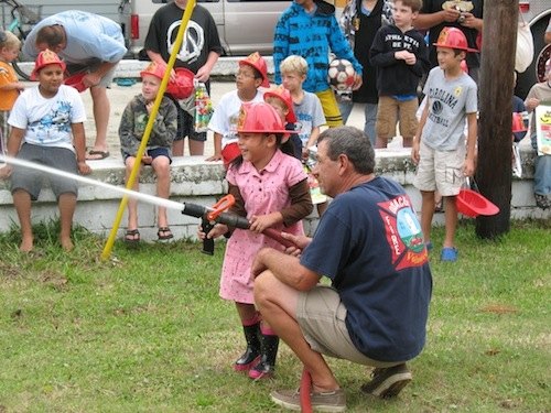 OVFD firefighter John Ferrara helps Yuletzy Hernandez with the water hose.