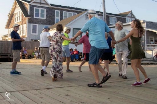 Still celebrating community. Philip Howard calls a square dance on the new docks at the Community Square, built by the Ocracoke Foundation this summer.